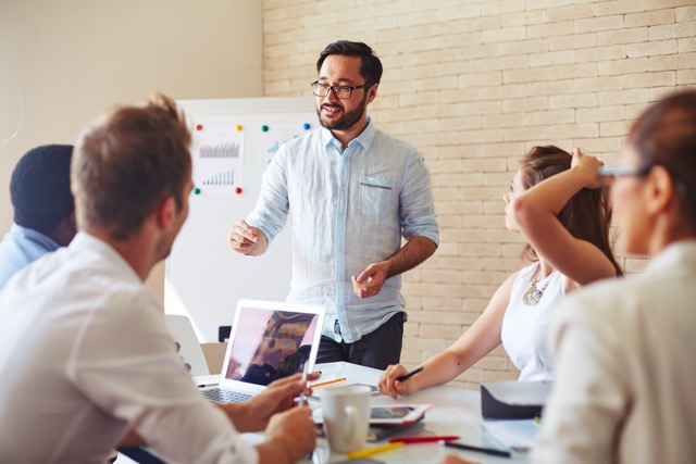 Modern businessman explaining his ideas to colleagues at a small seminar