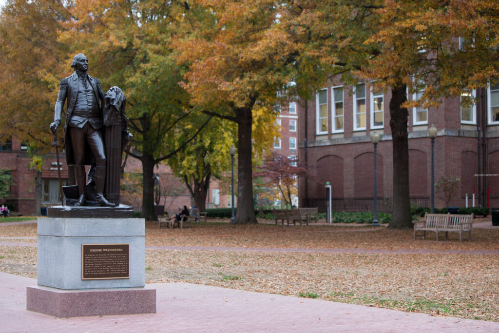 A statue of George Washington on the George Washington University campus during the fall season.